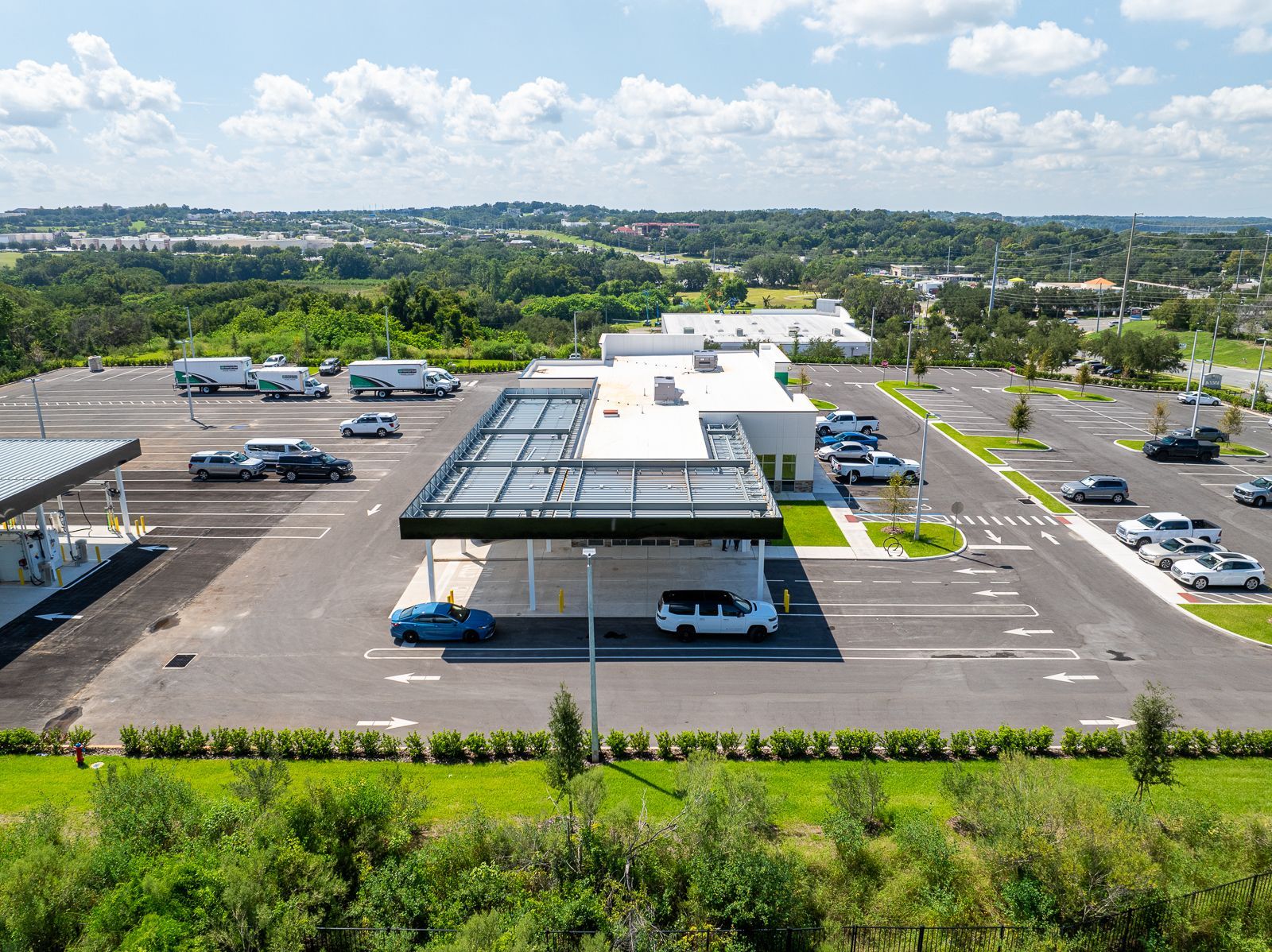 An aerial view of a parking lot with cars parked in front of a building.