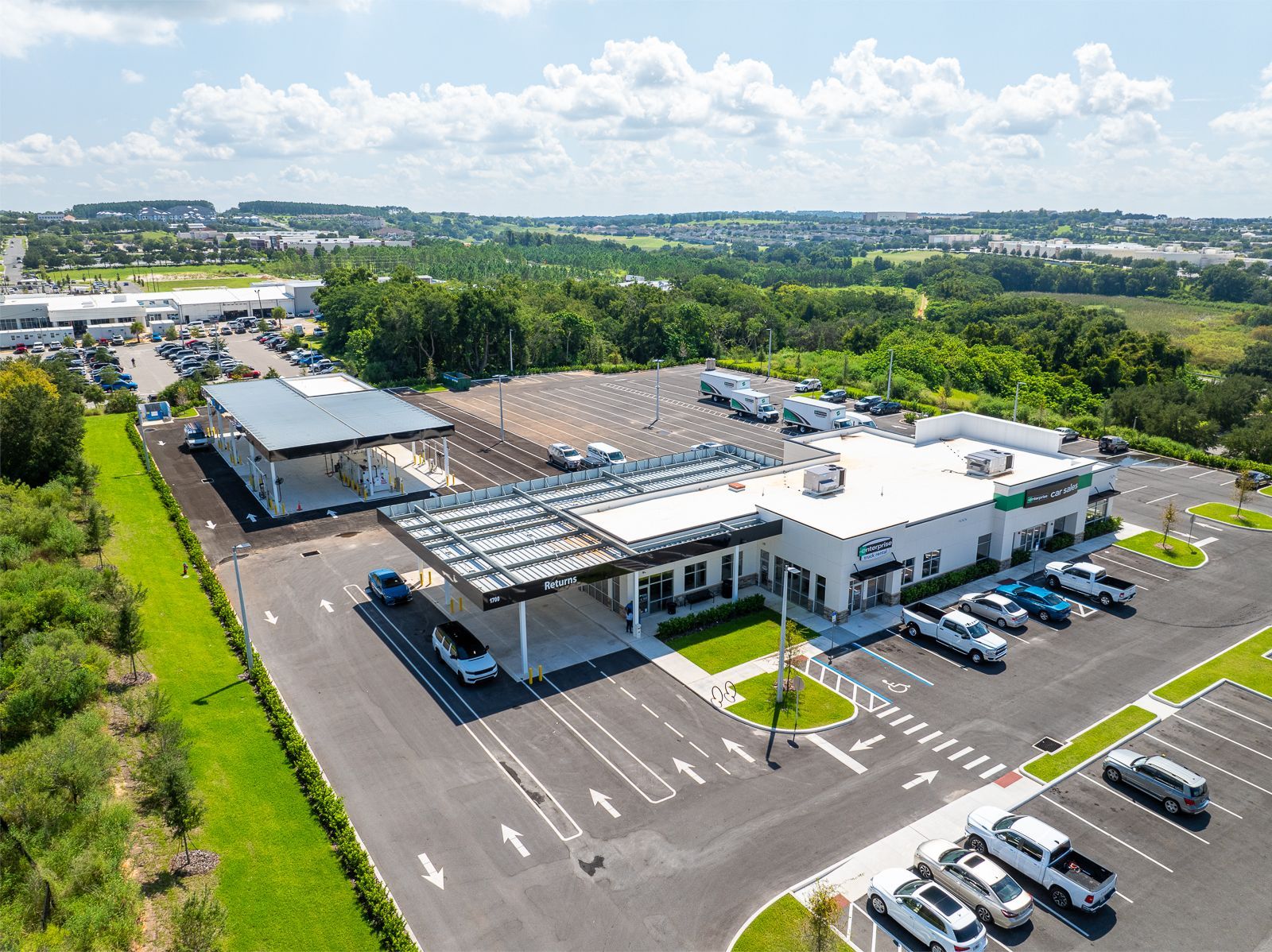 An aerial view of a parking lot with cars parked in front of a building.
