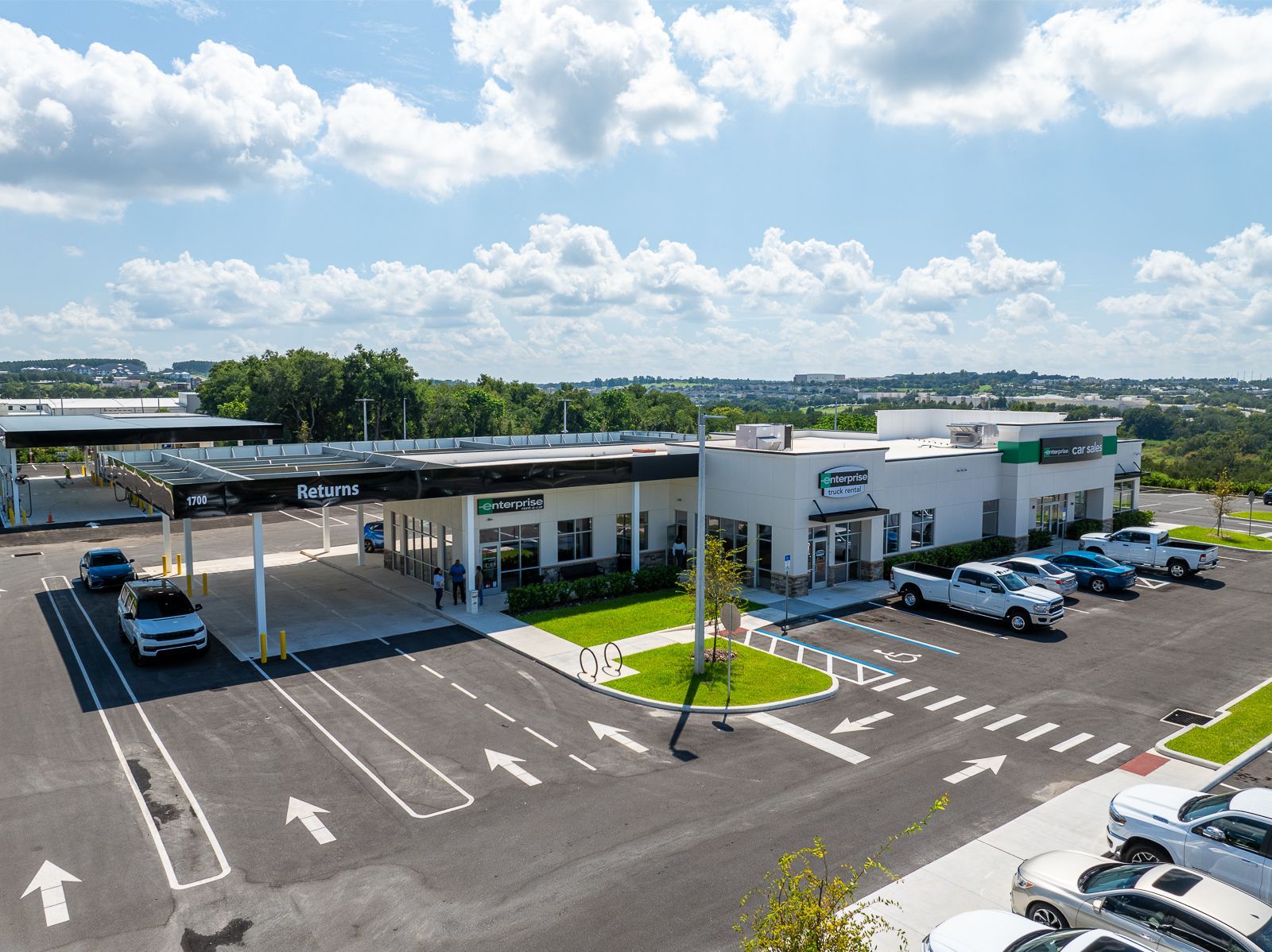 An aerial view of a parking lot with cars parked in front of a building.