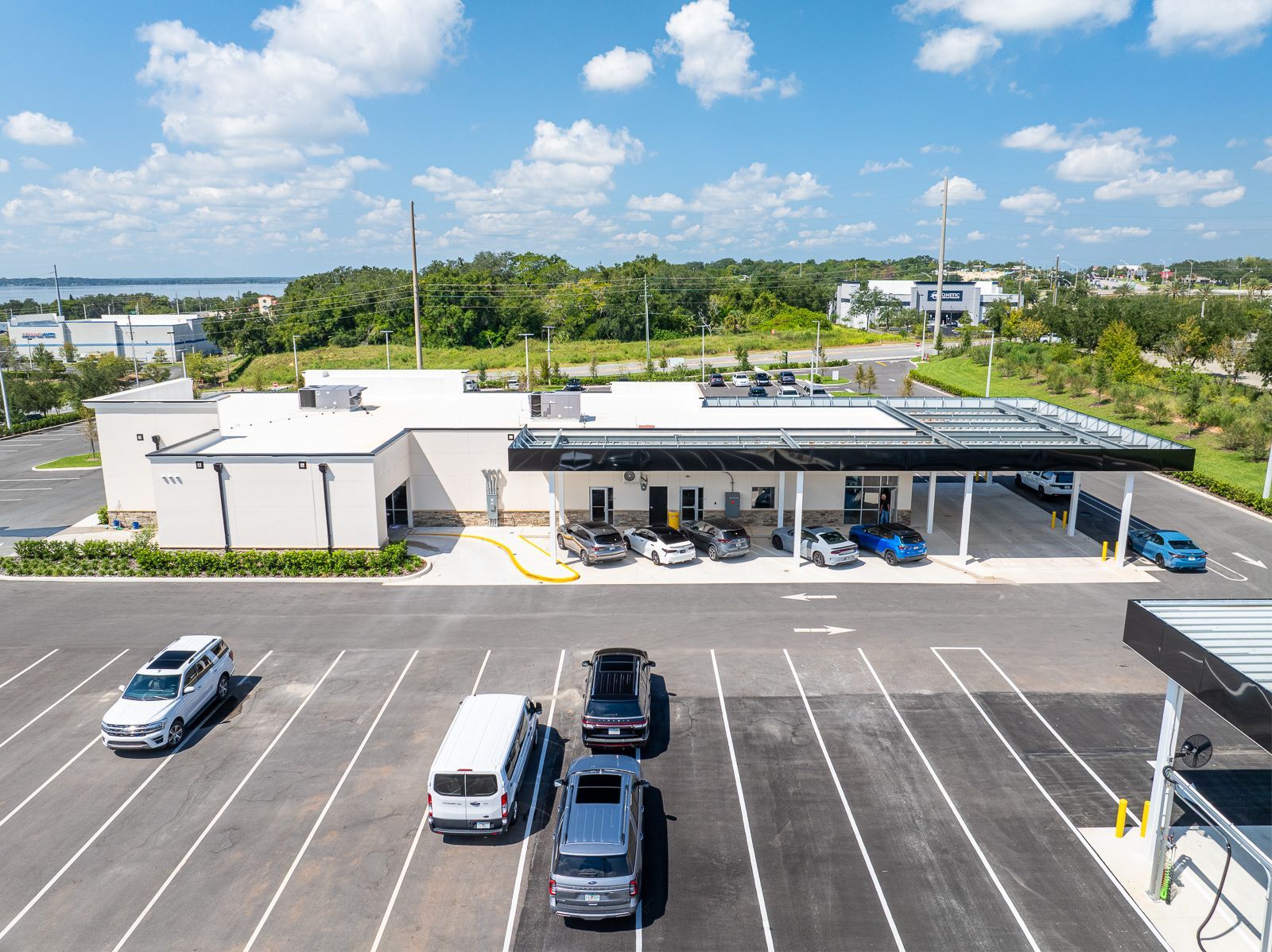 An aerial view of a parking lot with cars parked in front of a building.