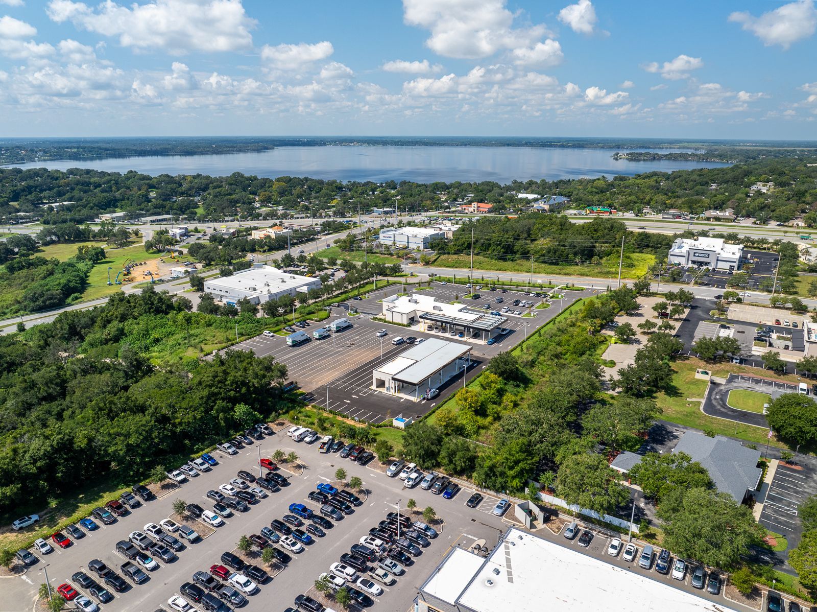 An aerial view of a parking lot in a city with a lake in the background.