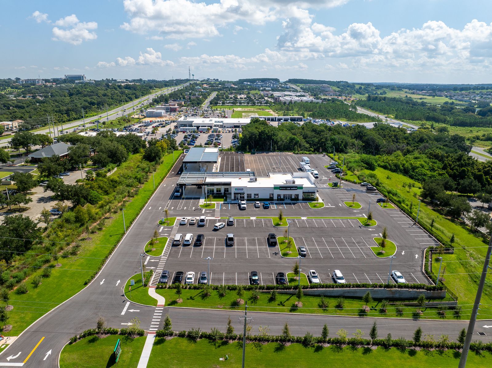 An aerial view of a parking lot with a building in the background.