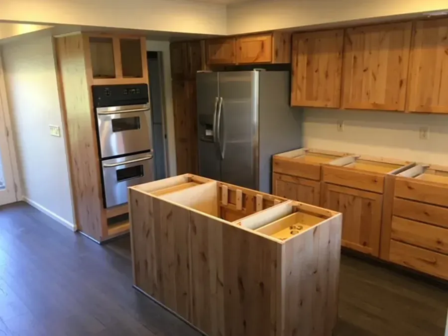 New kitchen with wooden cabinets, stainless-steel appliances, and an unfinished island in the center