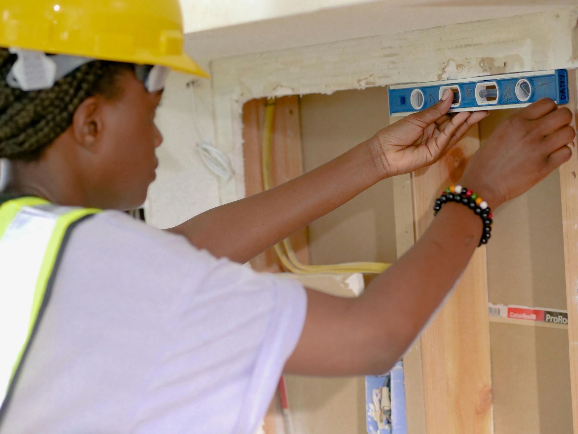 Person leveling a wooden frame with a spirit level during construction