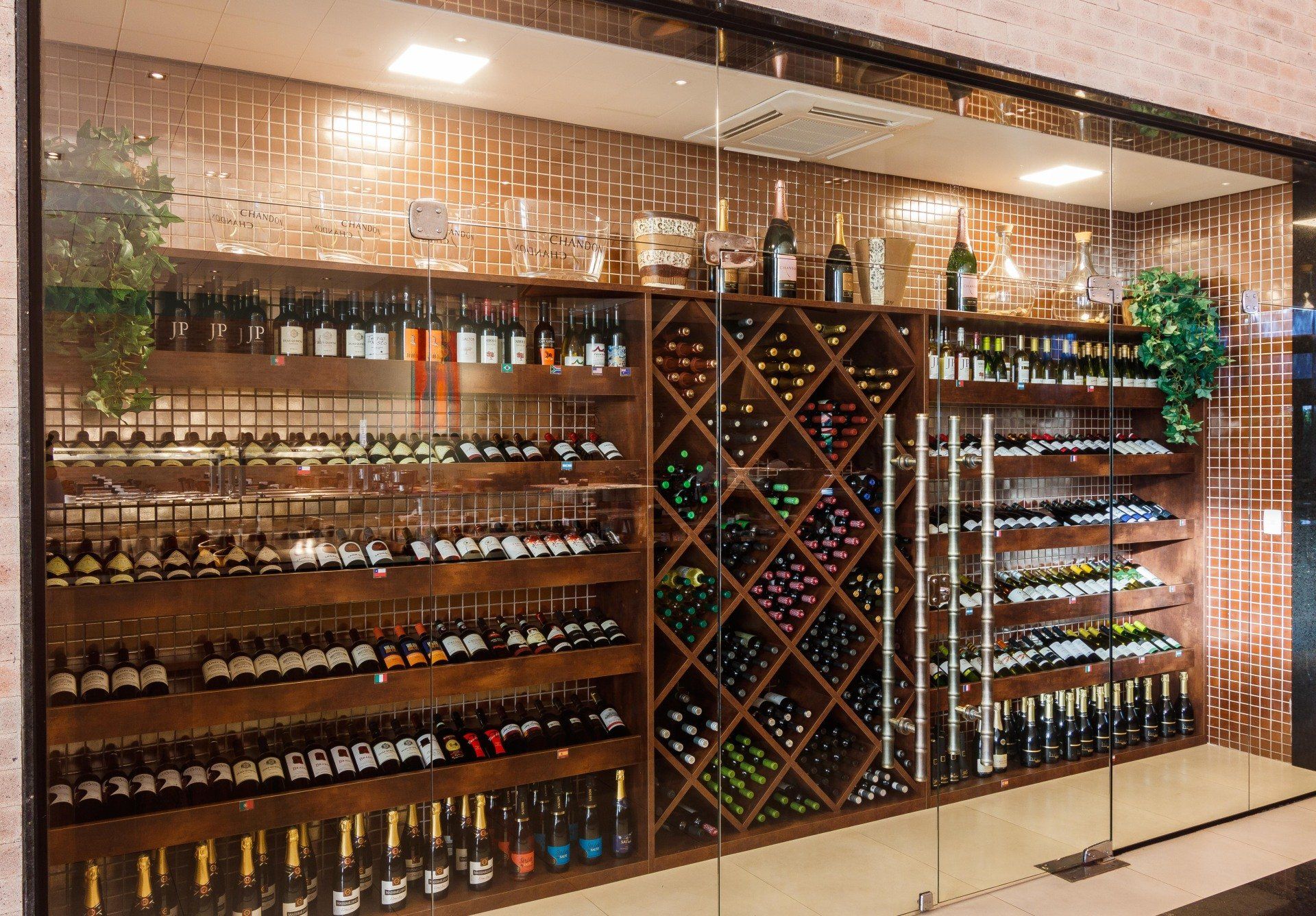 Uma adega cheia de garrafas de vinho e taças.