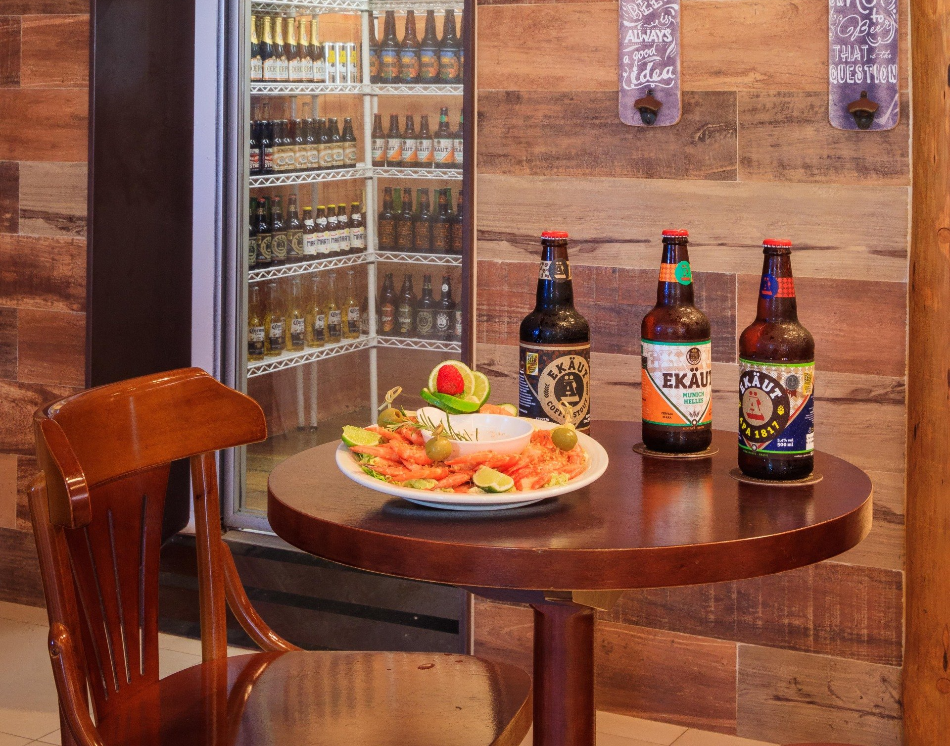 Uma mesa com três garrafas de cerveja e um prato de comida.