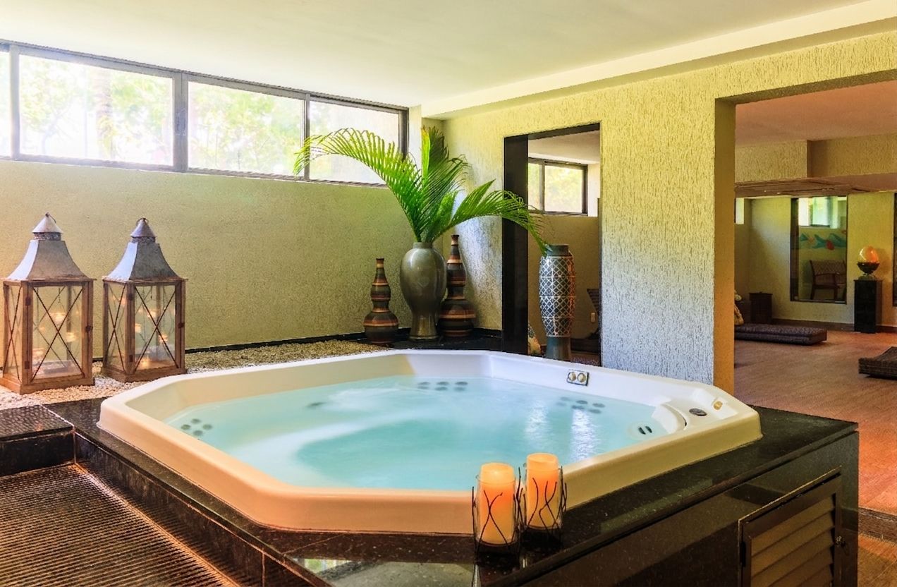 Uma jacuzzi cheia de água e velas em um spa.