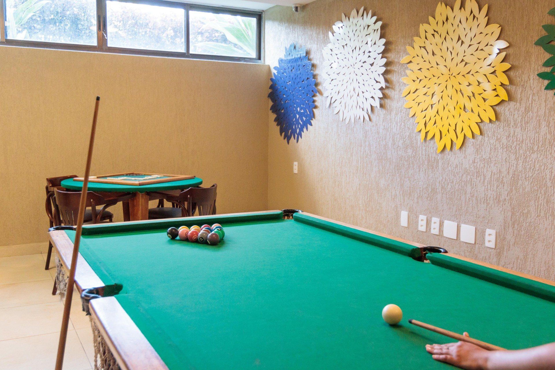 Uma pessoa está jogando sinuca em uma sala de jogos.