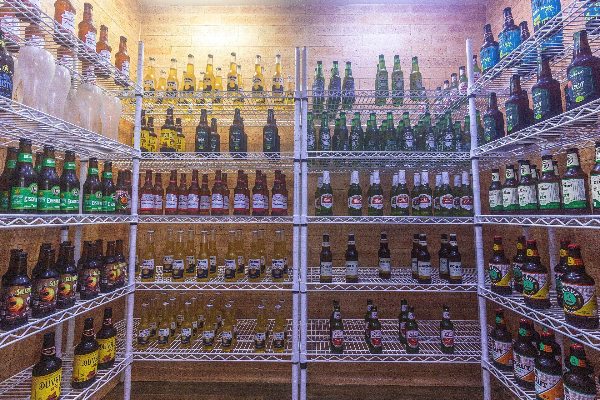 Uma sala cheia de garrafas de cerveja nas prateleiras