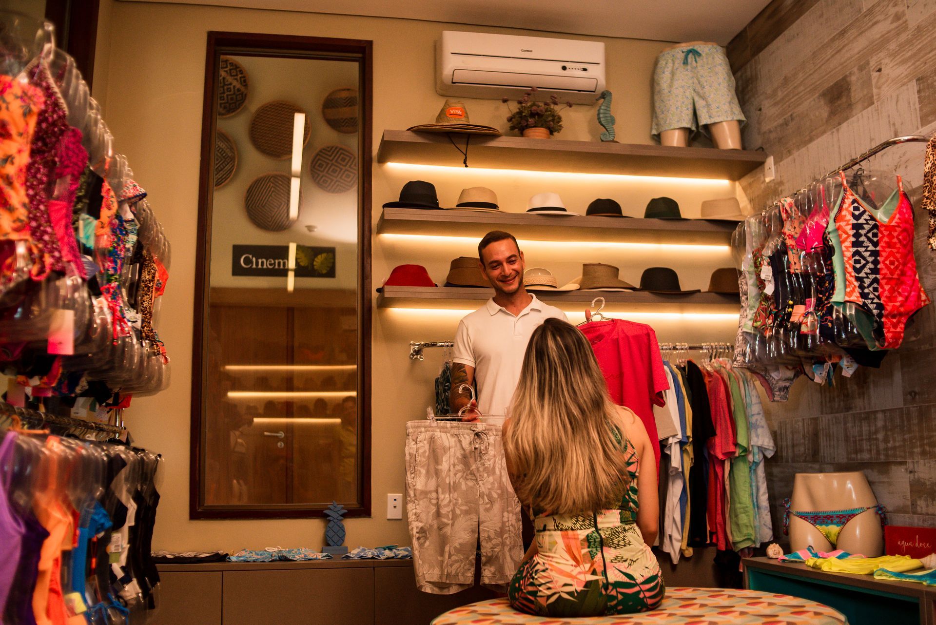 Um homem e uma mulher estão em uma loja de roupas.