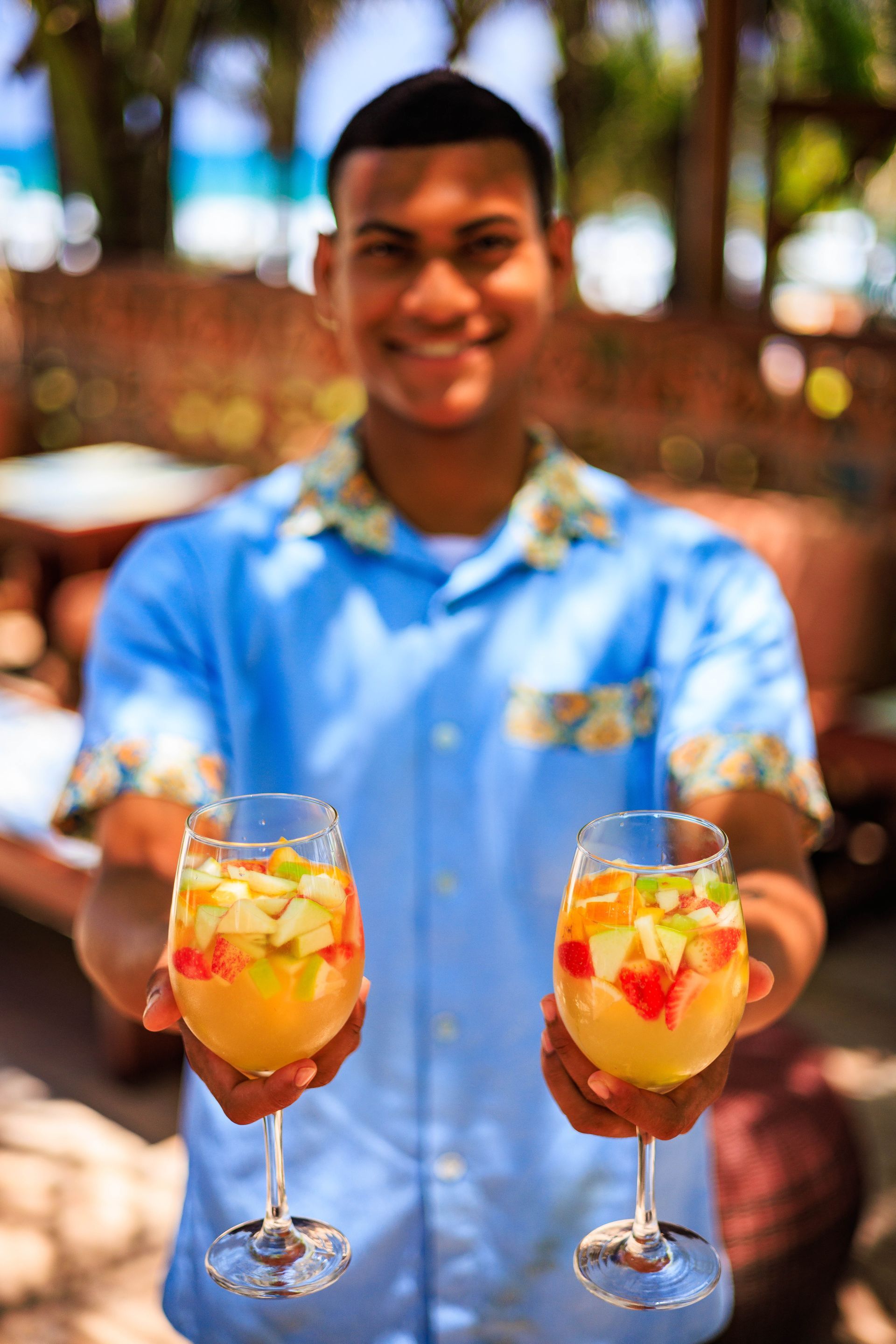 Um homem está segurando dois copos de bebidas frutadas.