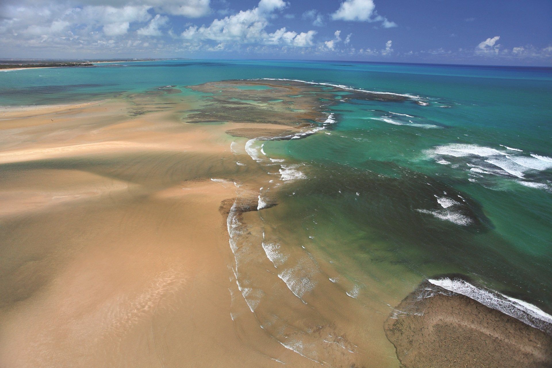 Uma vista aérea de uma praia com pedras na água