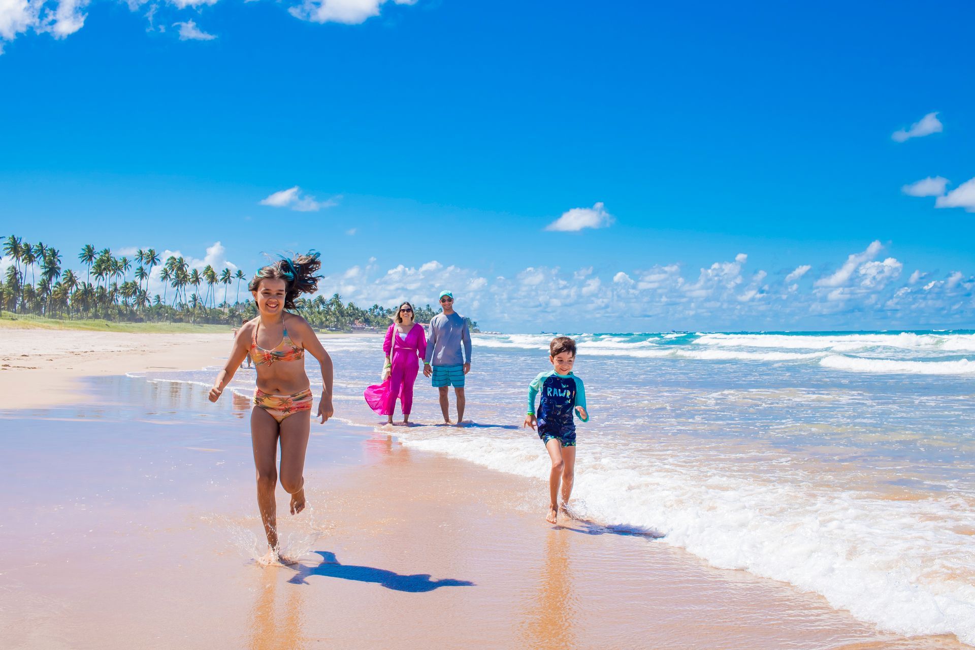 Uma família está correndo na praia.