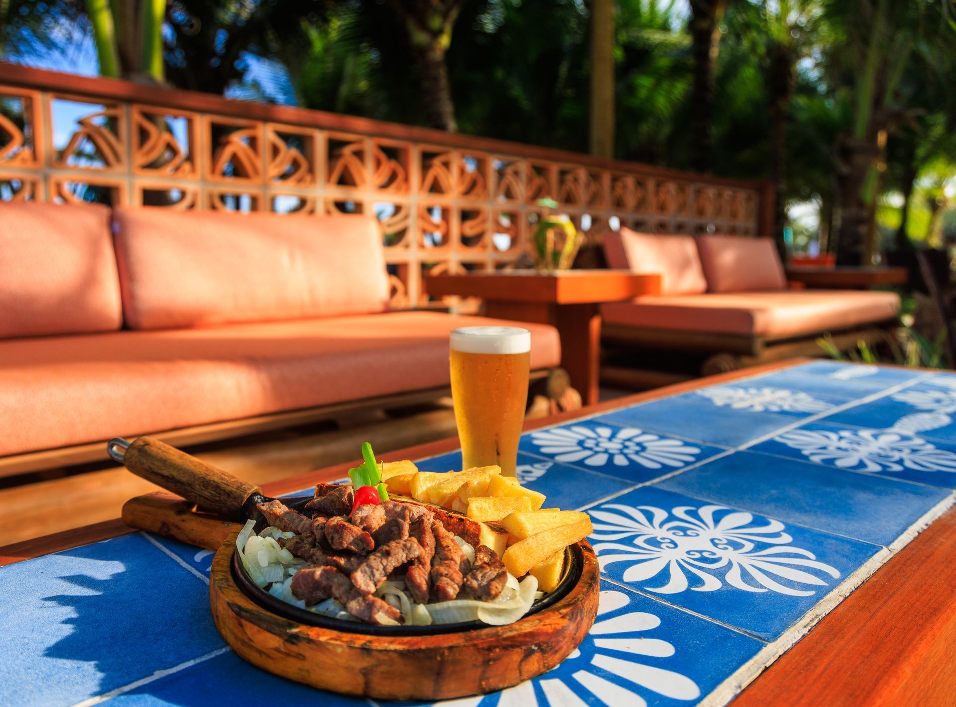 Um prato de comida e um copo de cerveja sobre uma mesa.