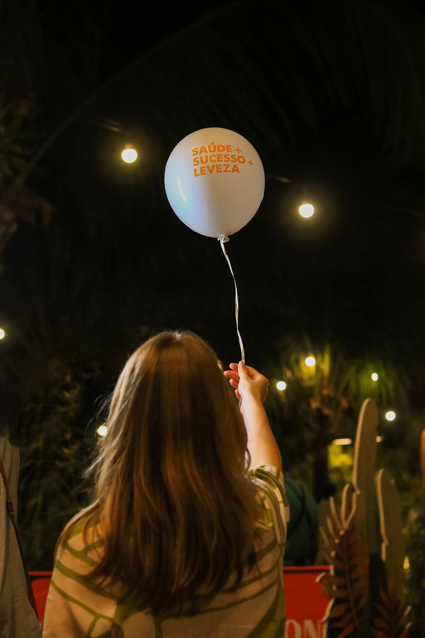 Uma mulher está segurando um balão branco que diz "eu te amo" nele.