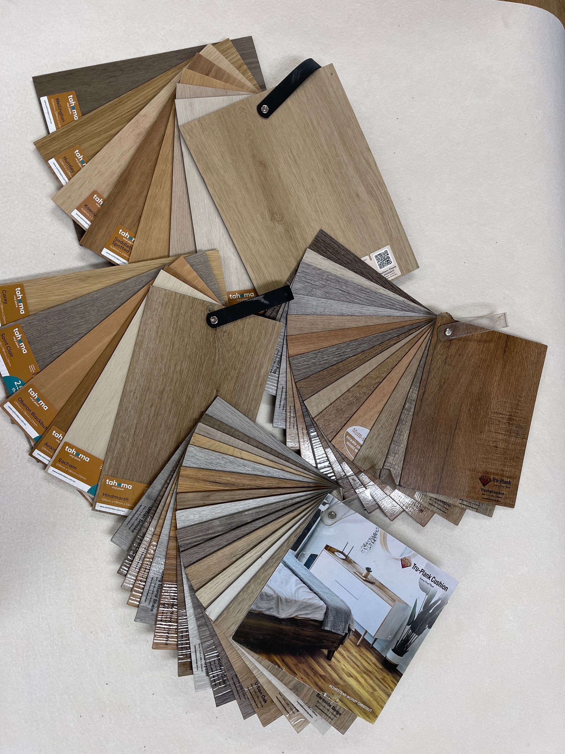 Swatches of various wood and flooring samples fanned out on a white surface.