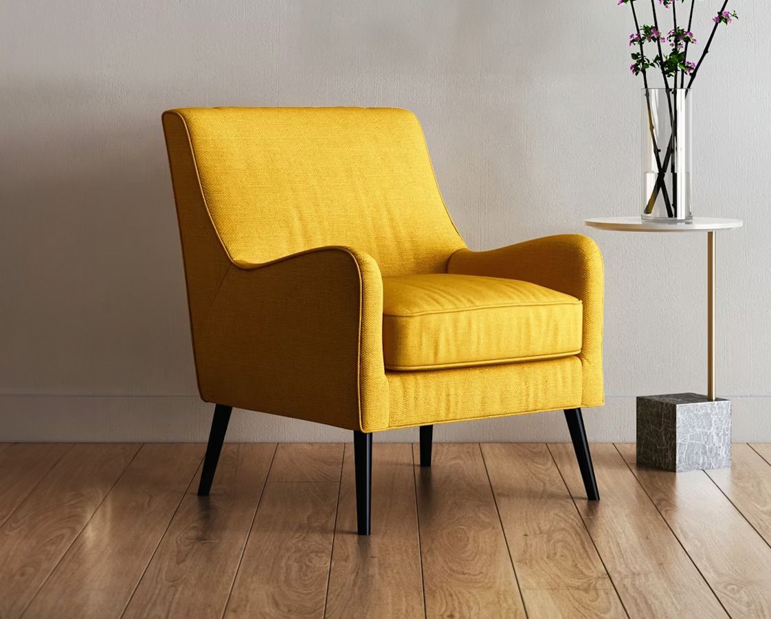 Yellow armchair with black legs next to a small table with flowers, on a wooden floor.