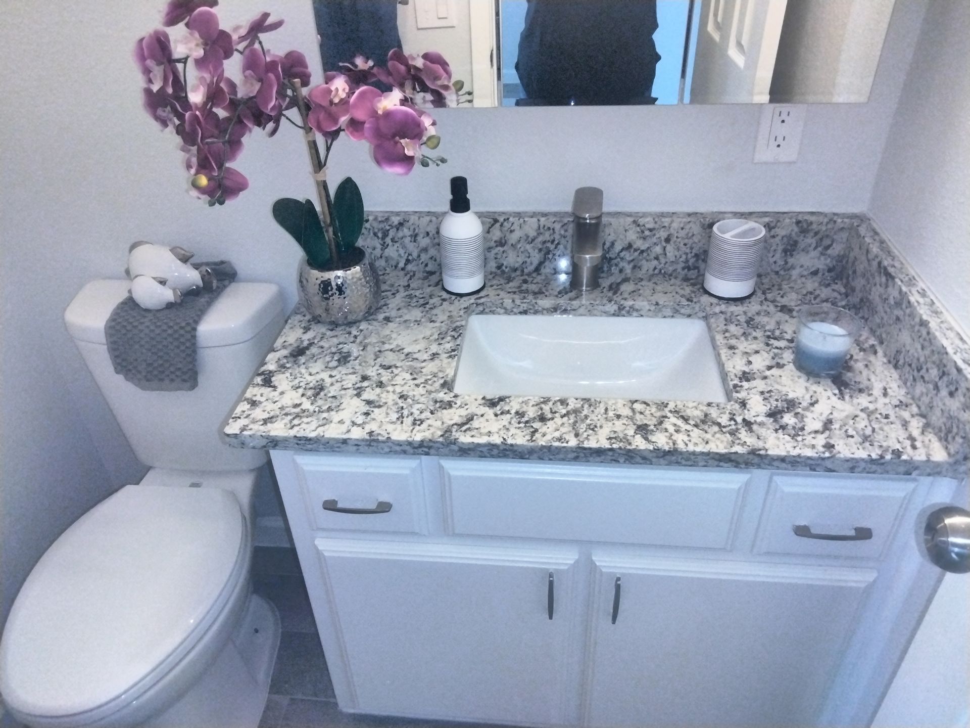 luxury upgraded bathroom with granite countertop sink, a toilet , and mirrored medicine cabinet