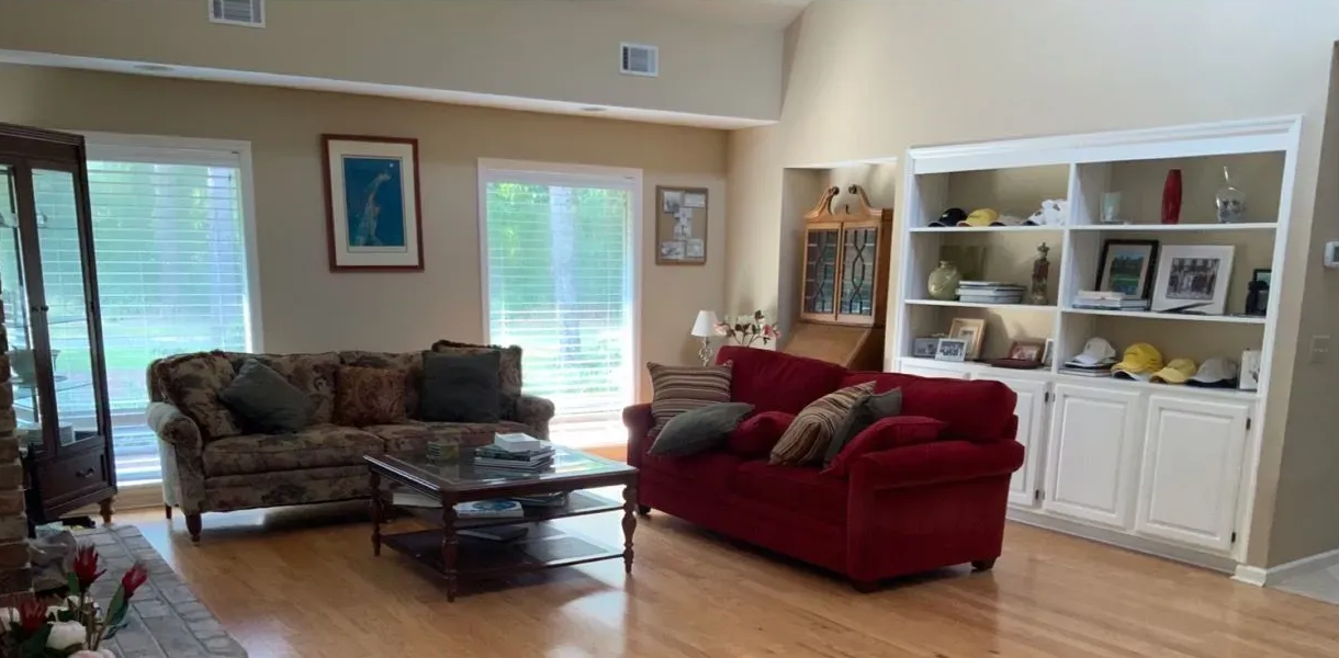 A living room with two couches, a coffee table, and a built-in bookshelf.