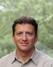 A man in a striped shirt is smiling for the camera.
