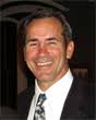 A man in a suit and tie is smiling for the camera.