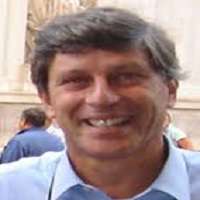 A man in a blue shirt is smiling for the camera.