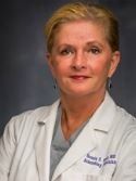 A woman in a white lab coat is posing for a picture.