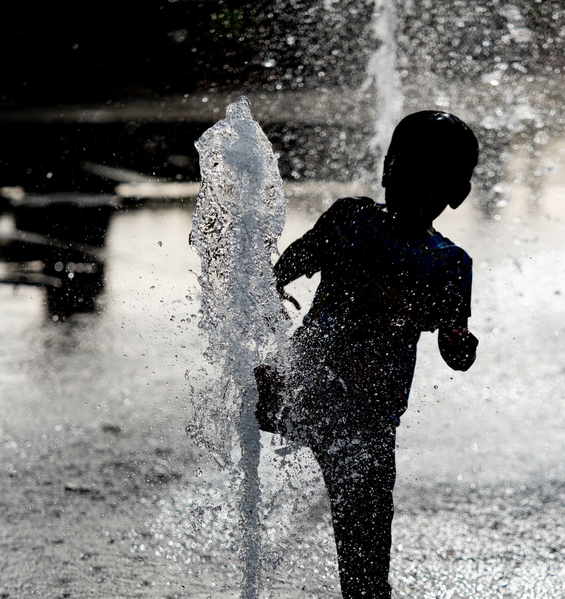 kid playing in water fountains