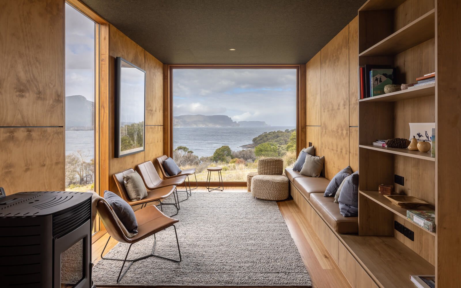 A living room with a large window and a view of the ocean.