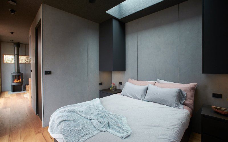A bedroom with a bed and a fireplace in the background.