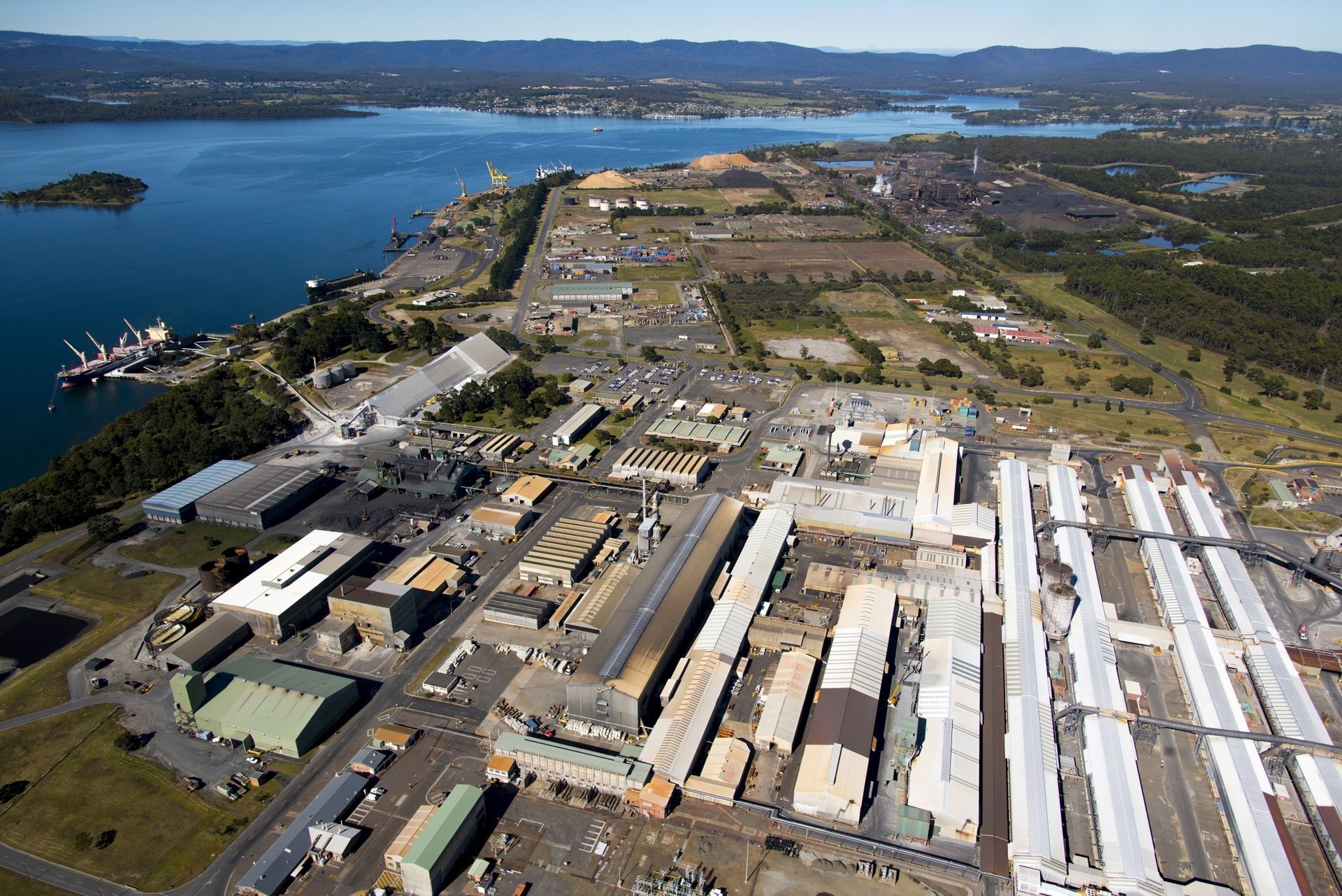 An aerial view of a large industrial area next to a body of water