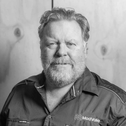 A man with a beard is wearing a black shirt with the word modware on it.