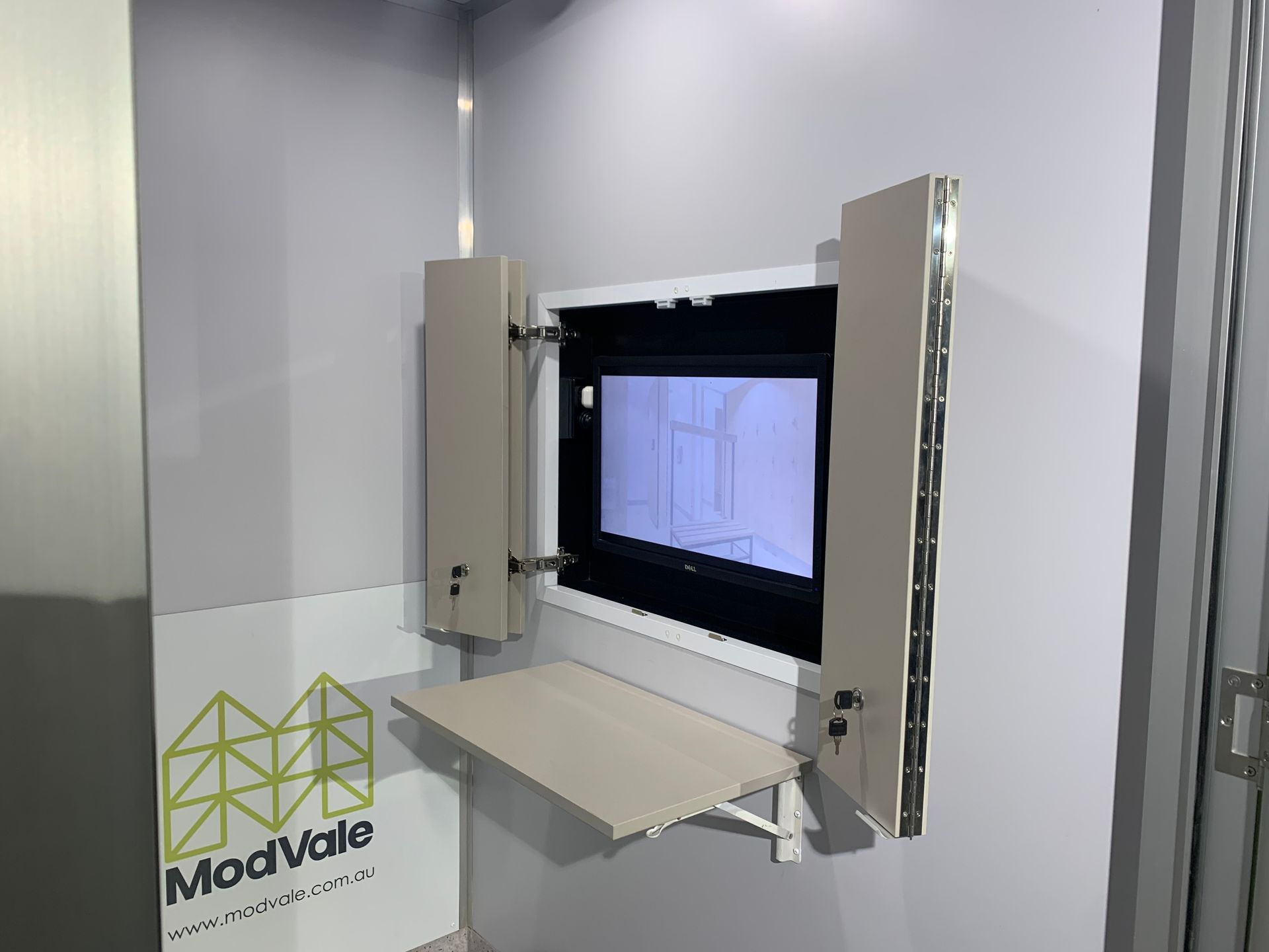A wall mounted tv with a table attached to it.