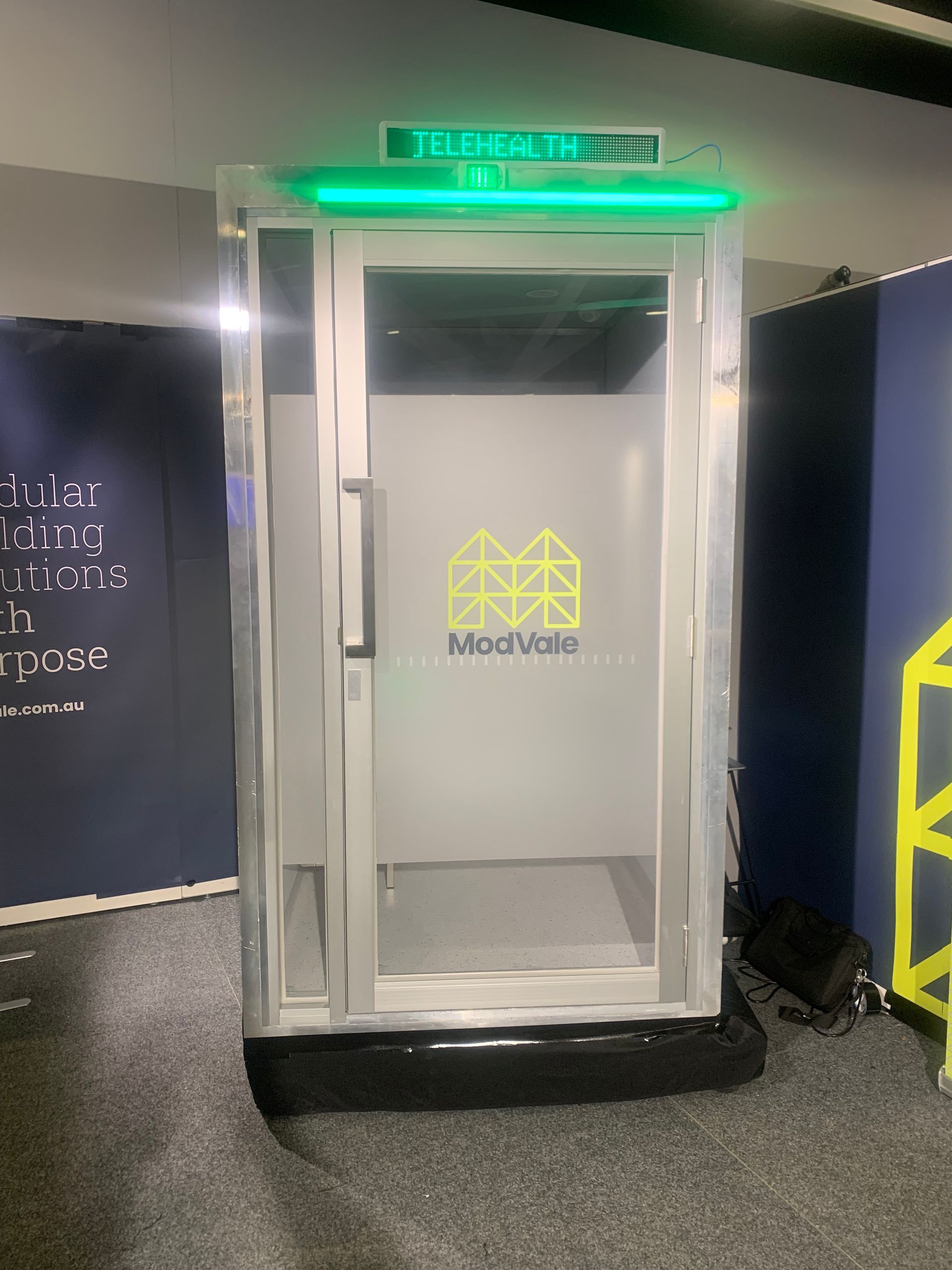 A phone booth with a green light on top of it.