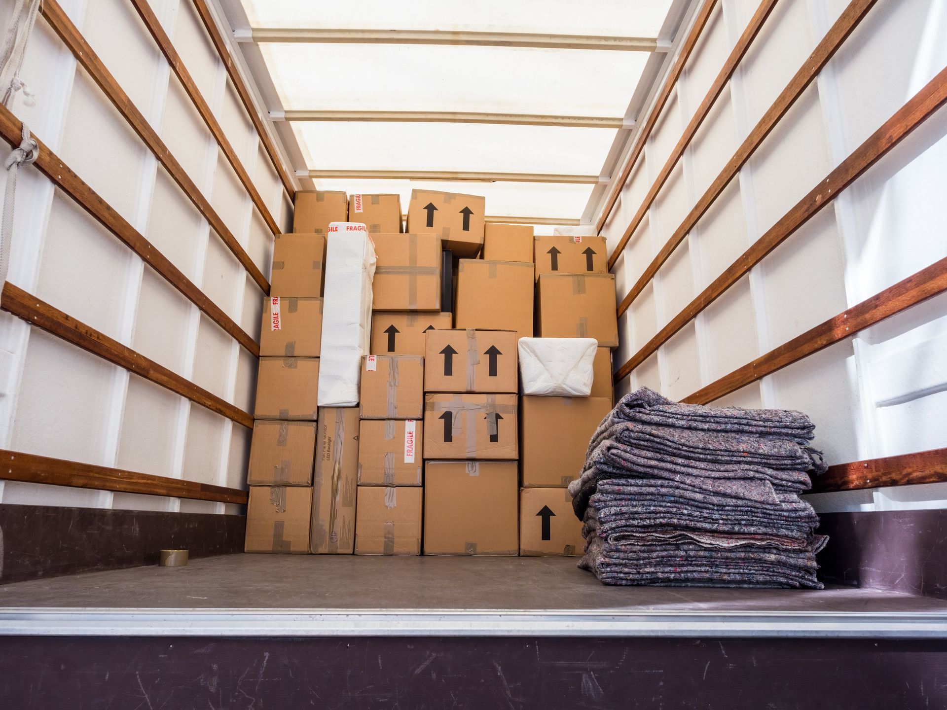 Boxes and packing materials fill a moving truck.