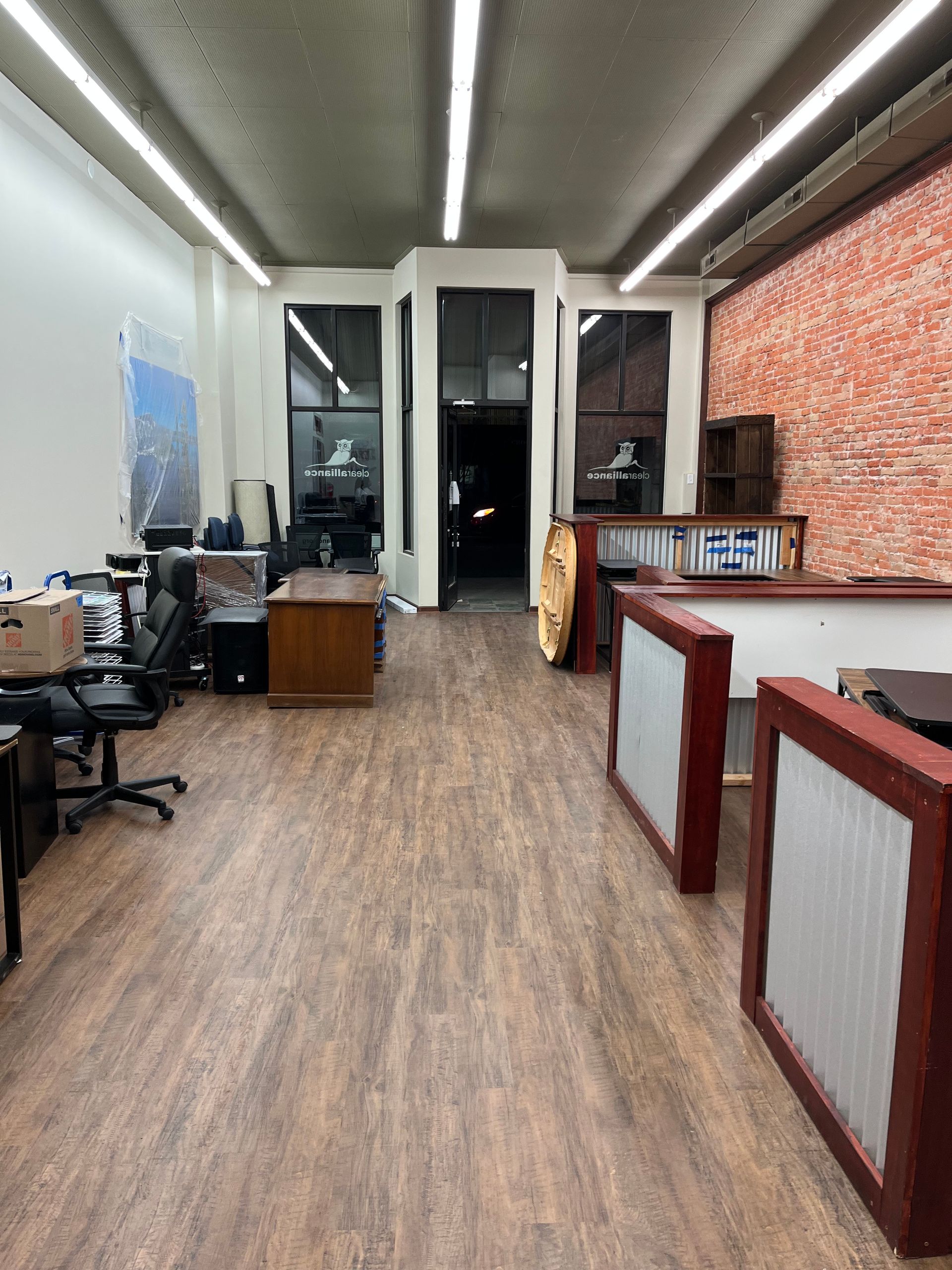 A large room with wooden floors and a brick wall