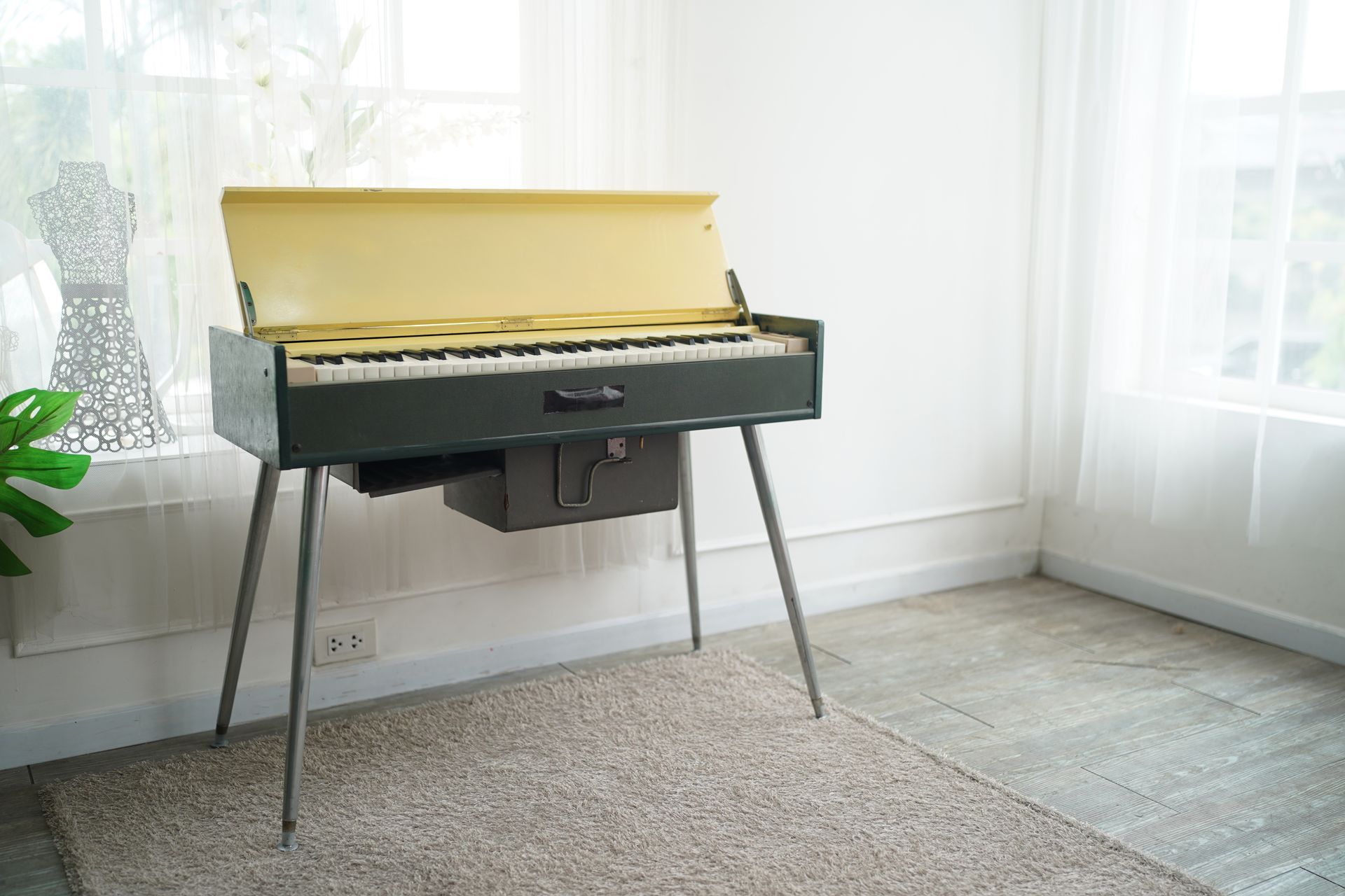 A piano is sitting on a table in a room next to a window.