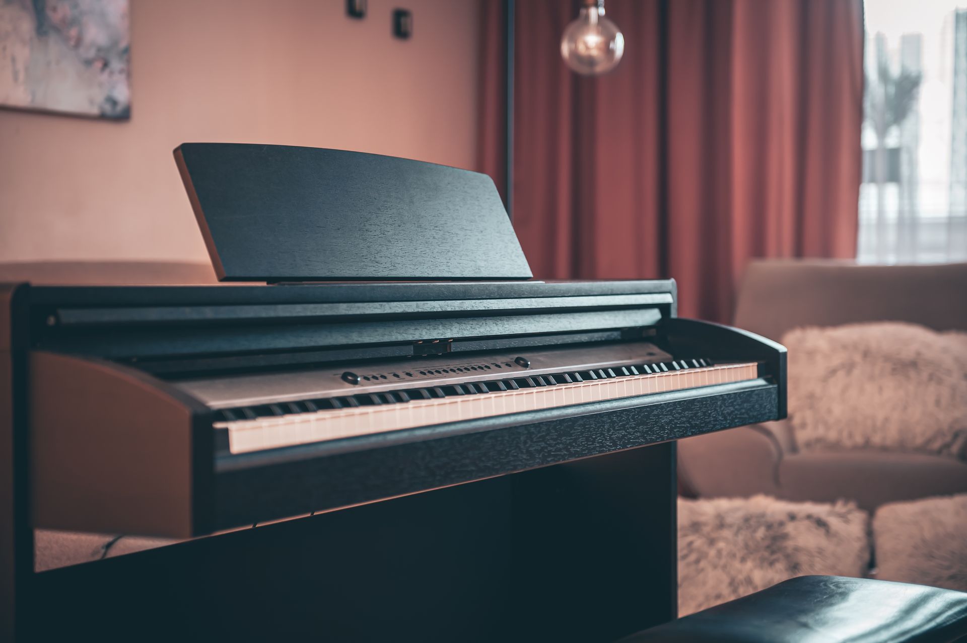 A piano is sitting in a living room next to a couch.
