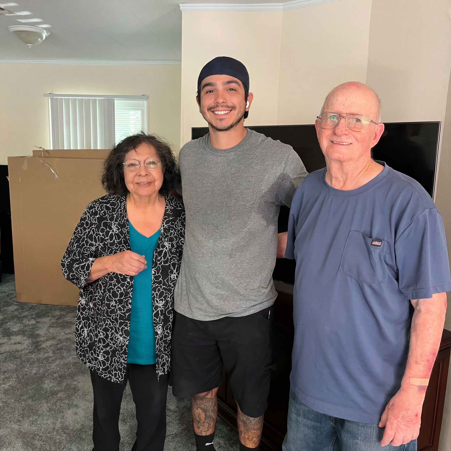 A woman and two men are posing for a picture in a living room.