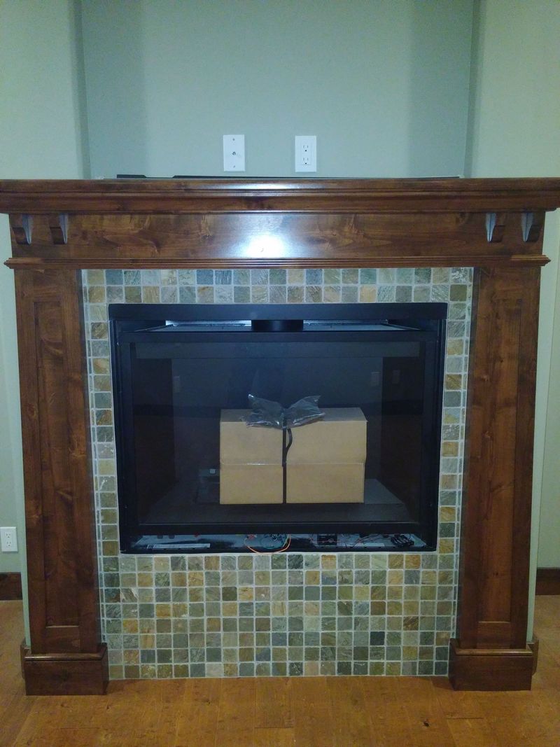 Fireplace with wood mantel and tiled surround, box inside.
