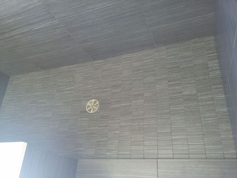 Dark gray tiled interior with a circular vent in the center of the wall.