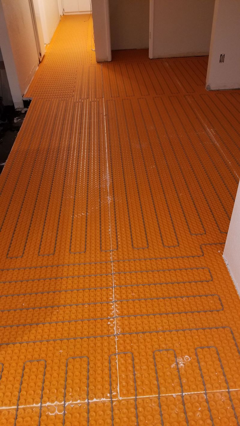 Orange radiant floor heating system installed on a floor in a room.