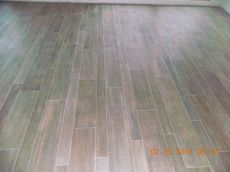 Wood-look tile flooring in shades of brown and gray, installed in a staggered pattern.