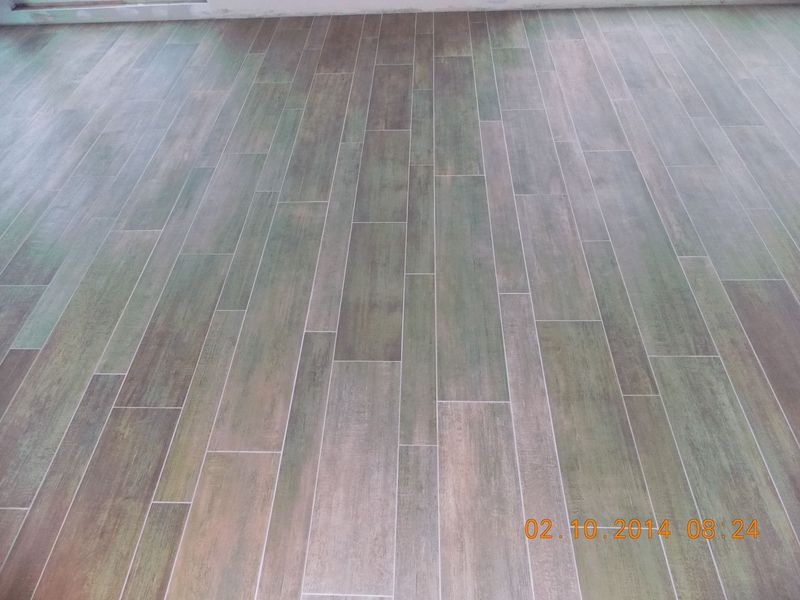 Wood-look tile flooring in shades of gray and brown, installed in a staggered pattern.