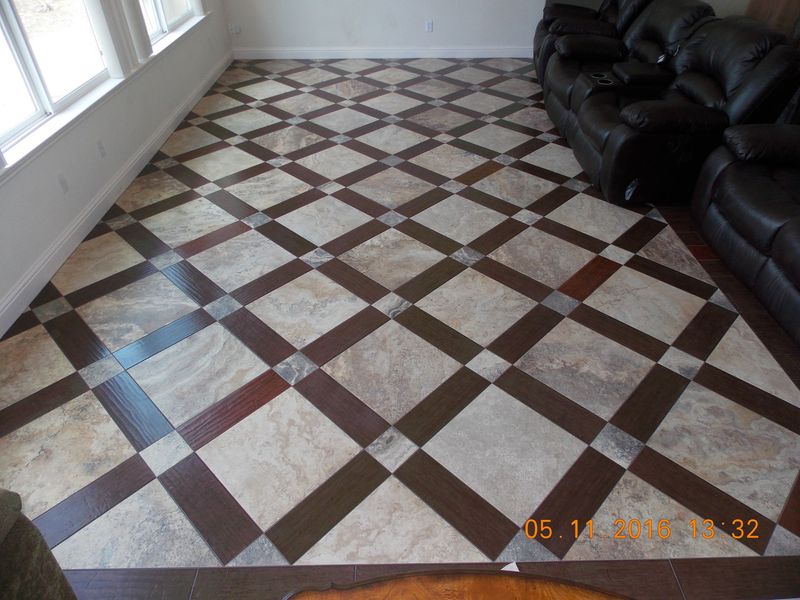 Tiled floor with a brown and tan checkerboard pattern.  Dark leather couch sits on right.  White wall with window on left.