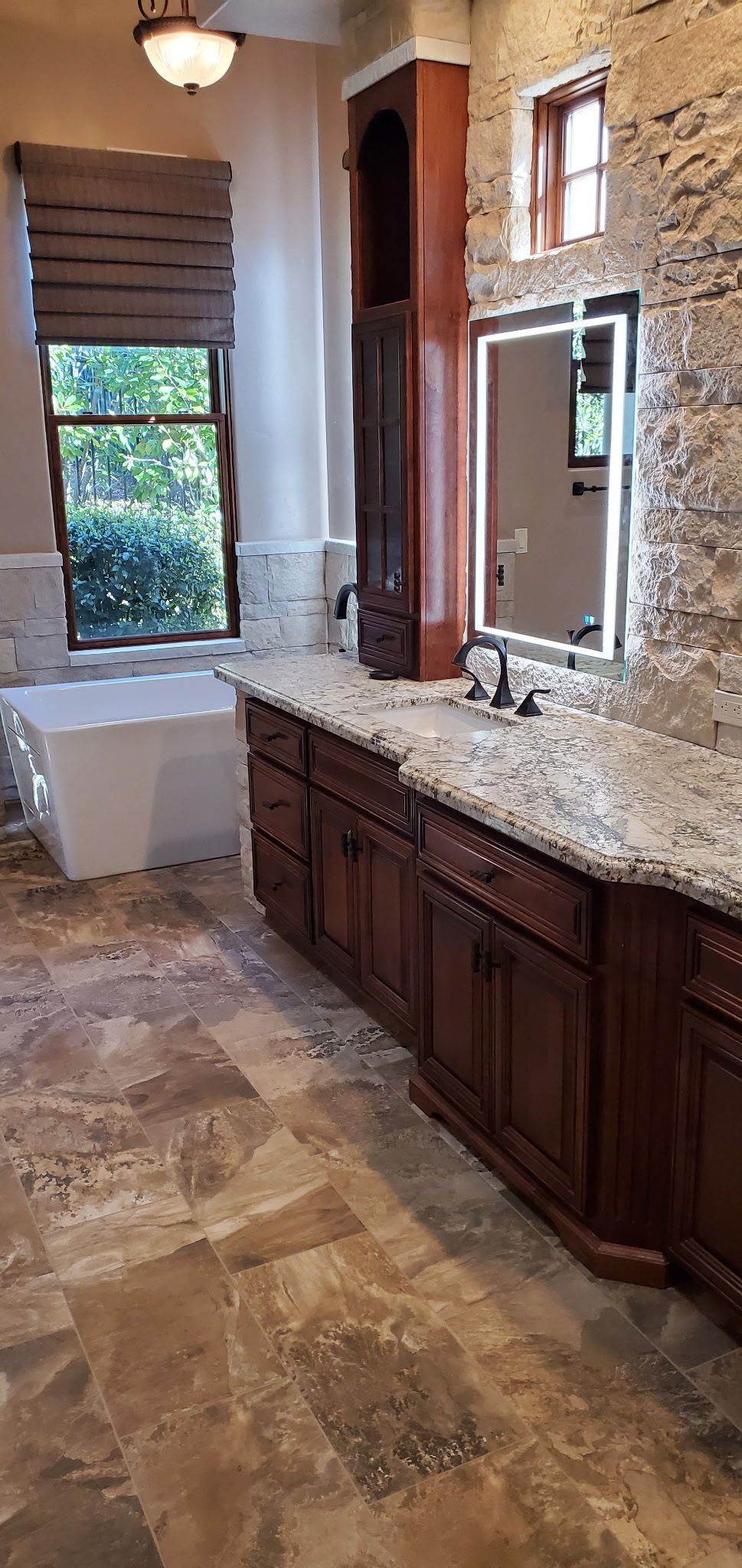 A bathroom with two sinks , a tub and a mirror.