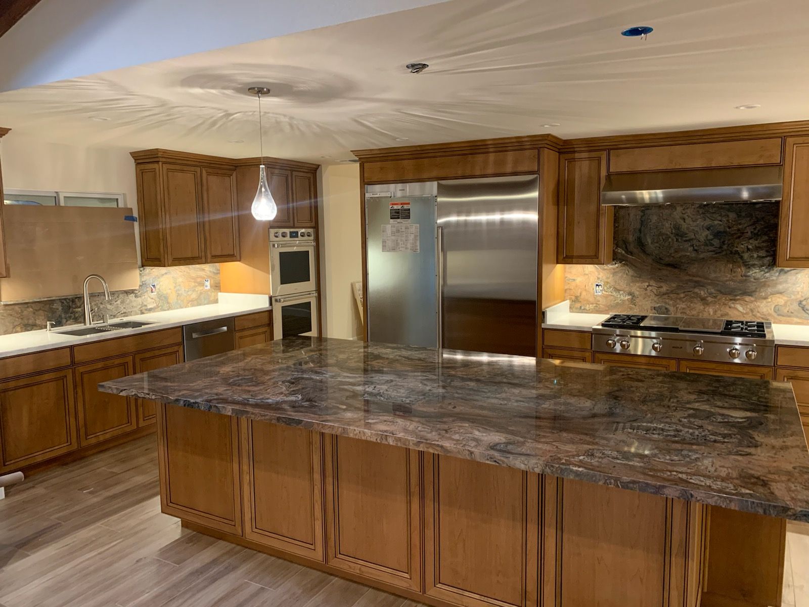 Kitchen with wooden cabinets, granite countertops, and stainless steel appliances.