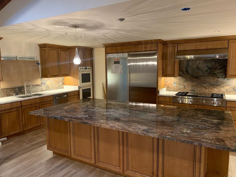 Kitchen with wooden cabinets, granite countertops, and stainless steel appliances.