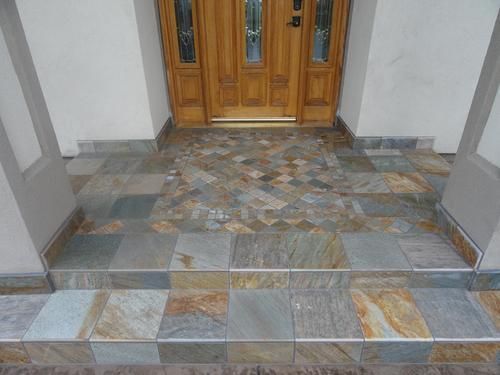 Entrance with stone tiles, steps, and wooden door. Slate blue, brown, and gold colors.