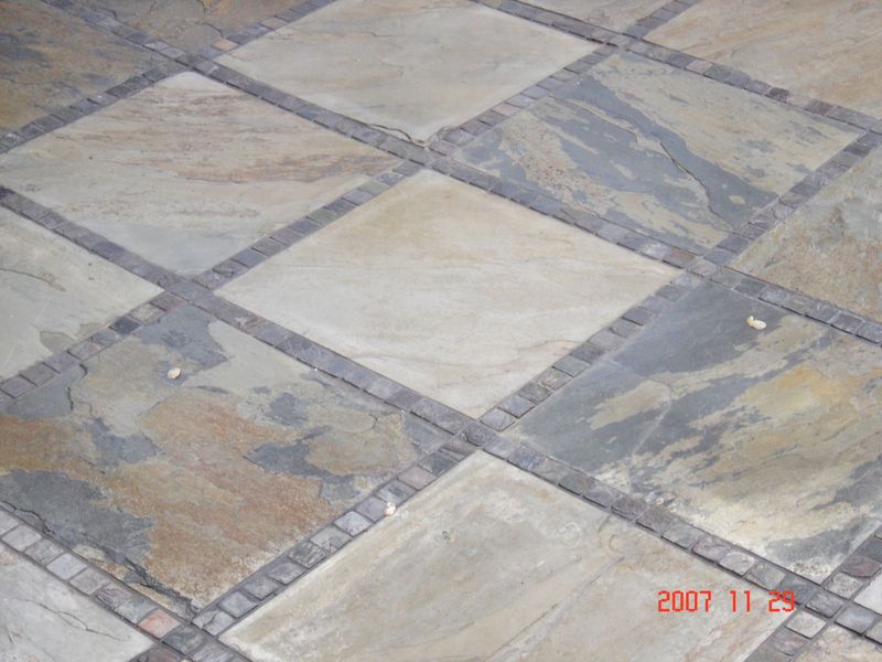 Diamond pattern stone tile flooring with a brick border.